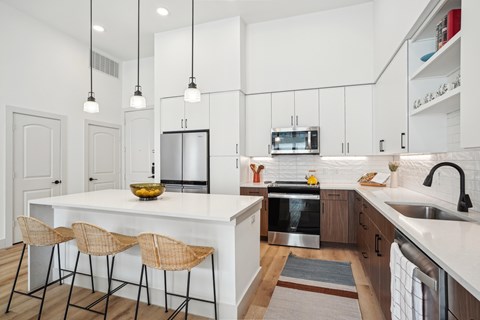A kitchen with a white countertop and a stainless steel oven.
