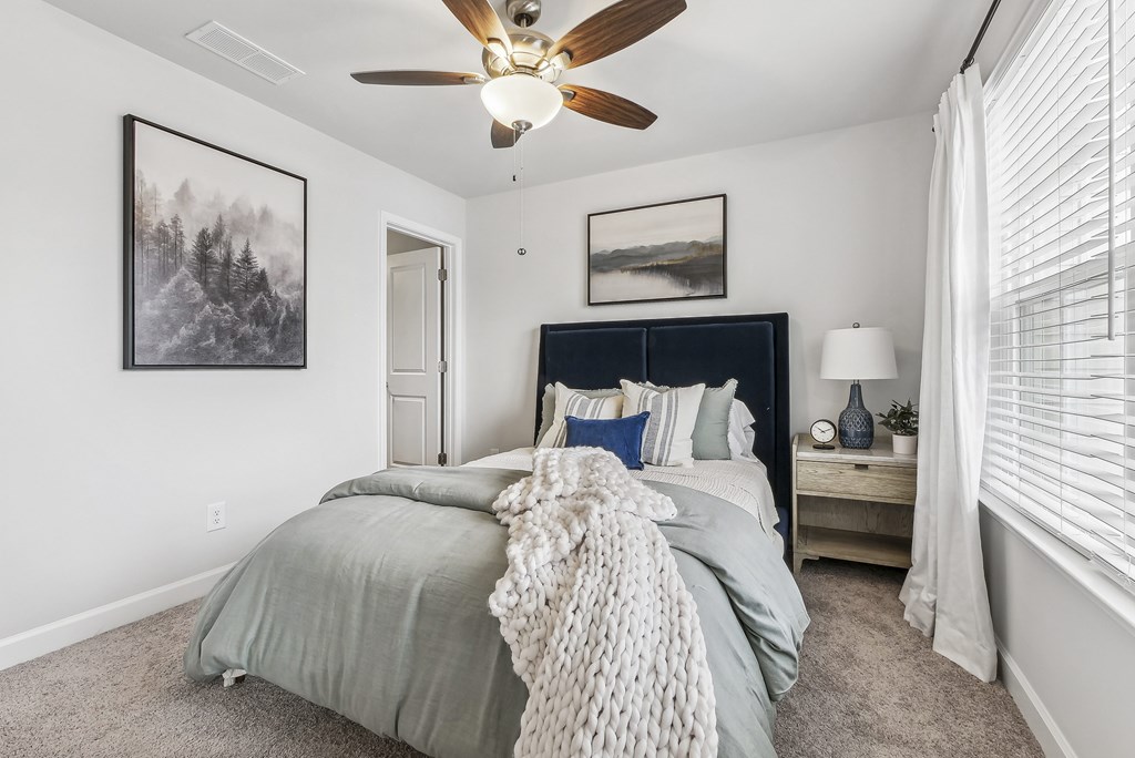 a bedroom with a bed and a ceiling fan