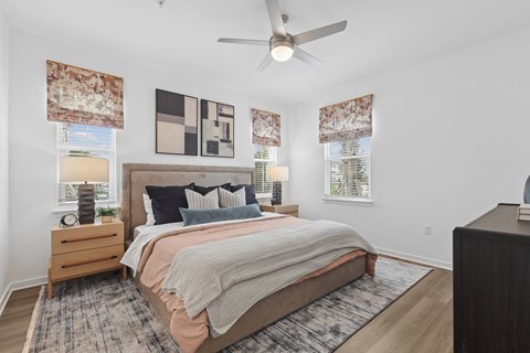 A bedroom with a large bed and a ceiling fan.
