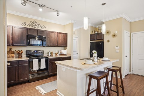 a kitchen with a center island and a counter top with bar stools