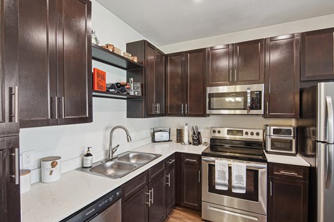 A kitchen with dark brown cabinets and stainless steel appliances.