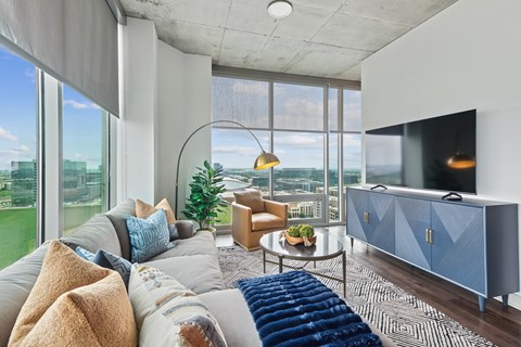 A modern living room with a grey sofa and a blue sideboard.
