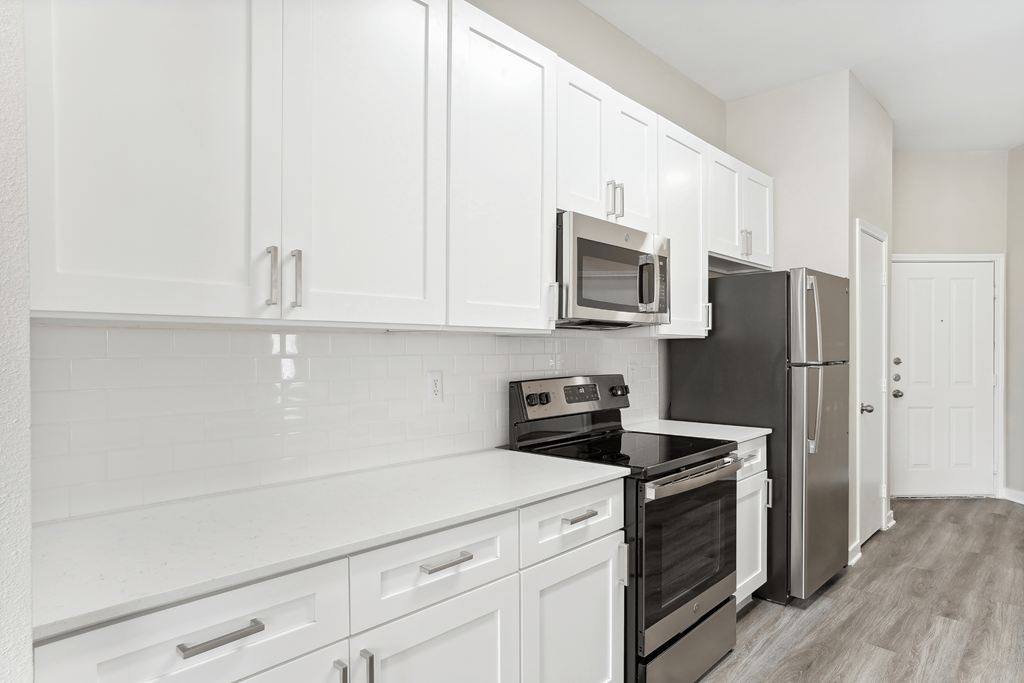 a kitchen with white cabinets and a stove and a refrigerator