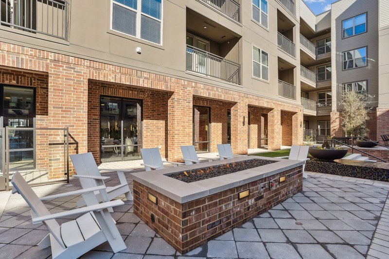 an outdoor patio with chairs and a fire pit