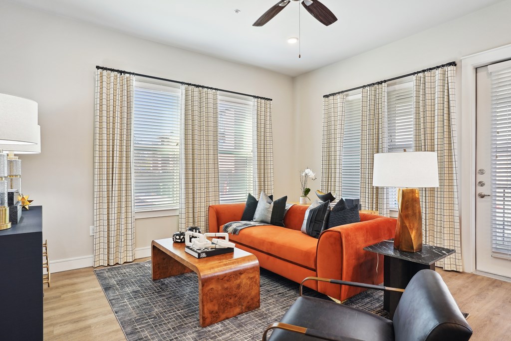Spacious living room with ceiling fan and large windows