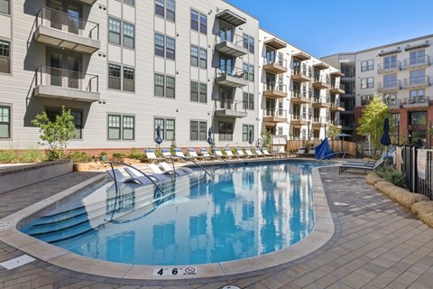 A swimming pool in front of apartment buildings.