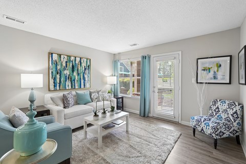 A living room with a white couch, a coffee table, and a painting on the wall.