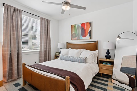 A bedroom with a large bed and a ceiling fan.