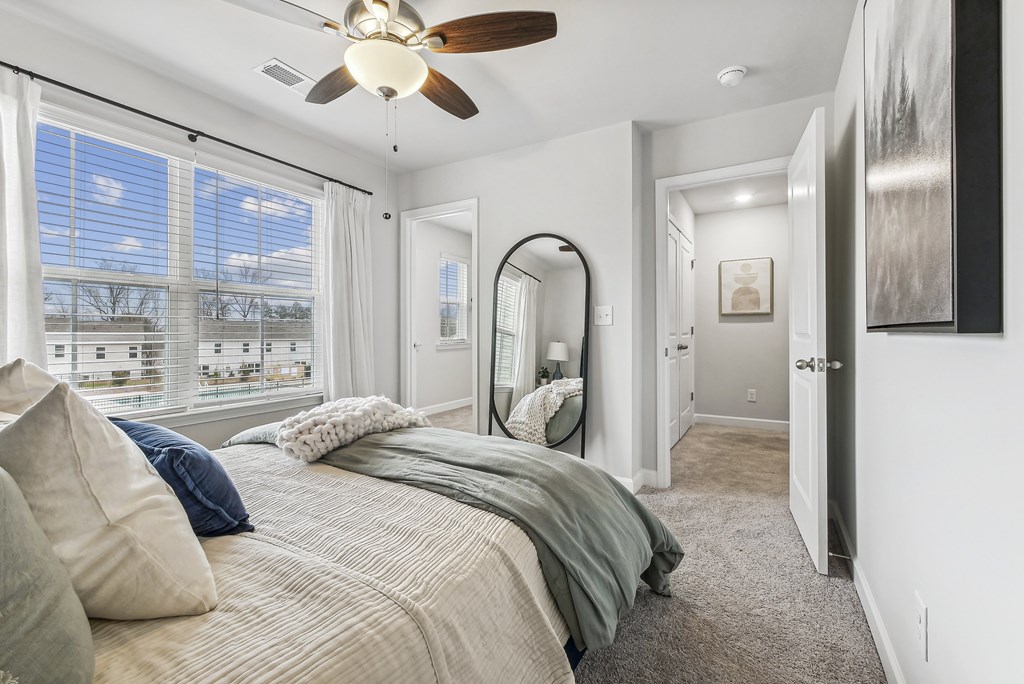 a bedroom with a large bed and a ceiling fan
