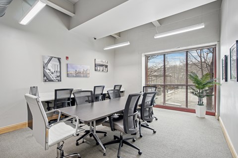 A conference room with a long table and chairs.