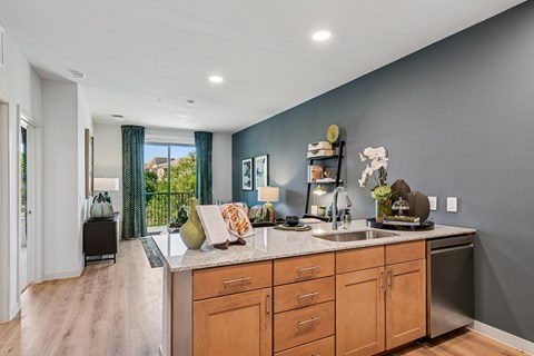 A kitchen with wooden cabinets and a large island with a sink.