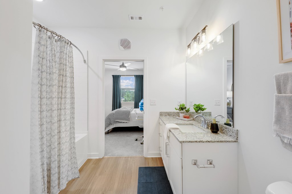 a bathroom with a shower and a sink and a mirror