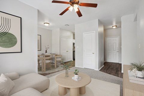 A living room with a white couch and a brown coffee table.