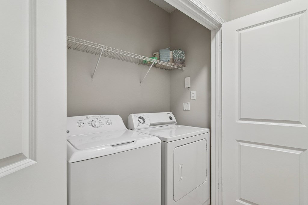 A white laundry room with a washer and dryer.
