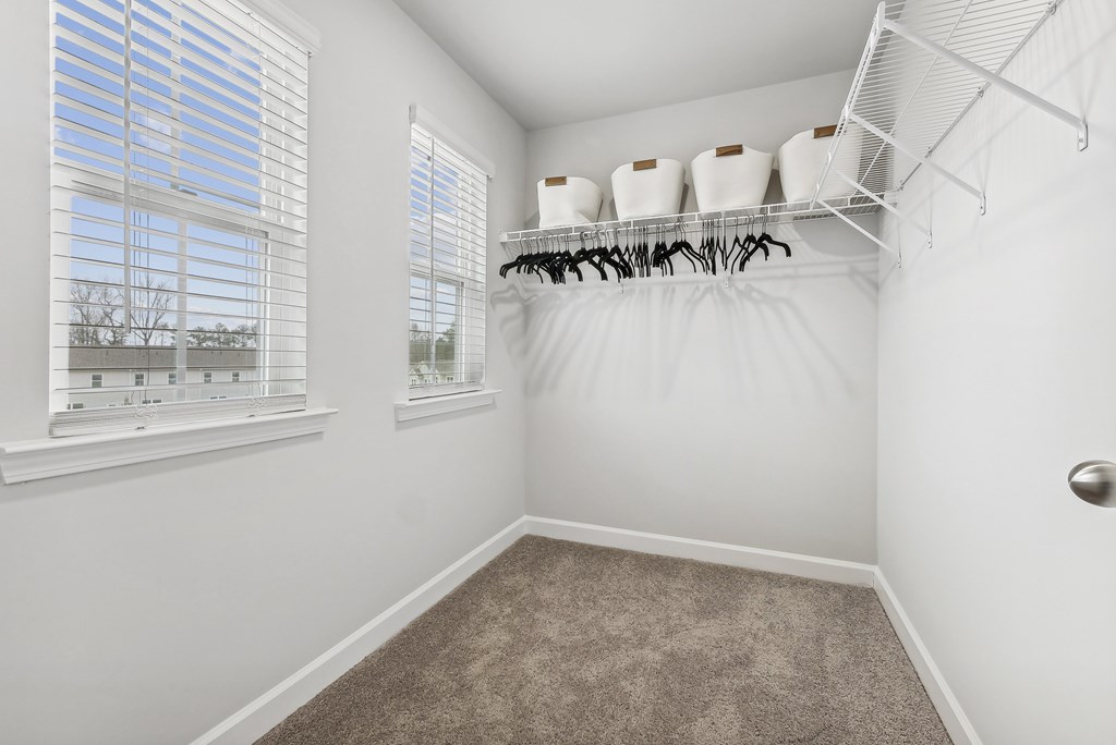 an empty room with a closet with white walls and a window