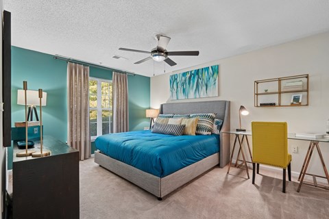 A bedroom with a bed, desk, and chair.