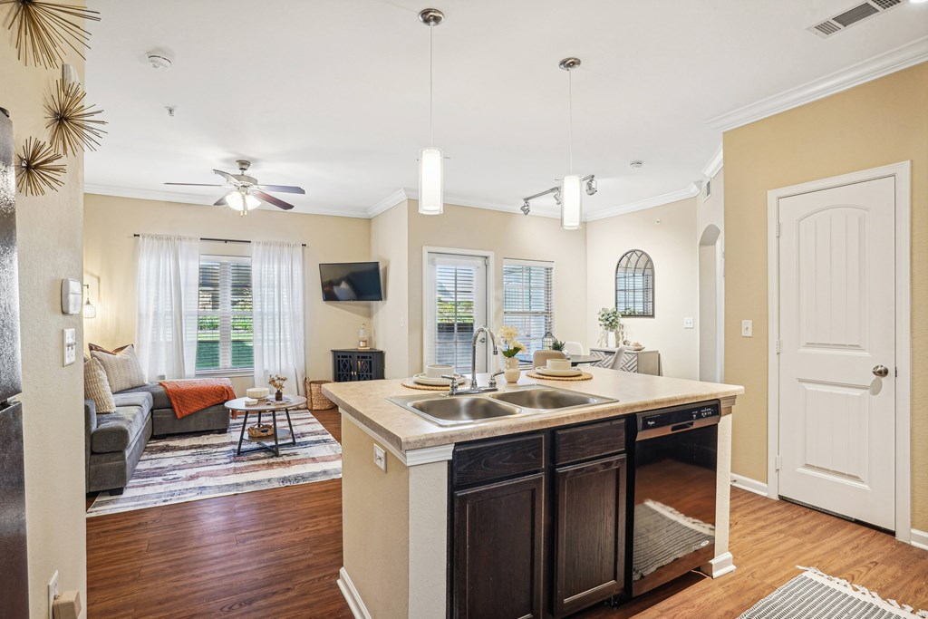 a kitchen with a sink and a living room with a couch