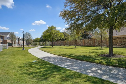 A pathway in a park with trees on the side.