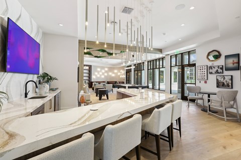 A modern dining room with a long table and chairs.