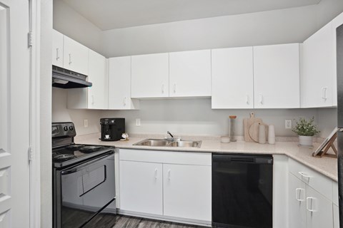A modern kitchen with white cabinets and appliances.