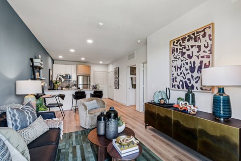 A living room with a black couch and a gold sideboard.