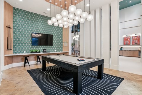 A room with a pool table and a television.