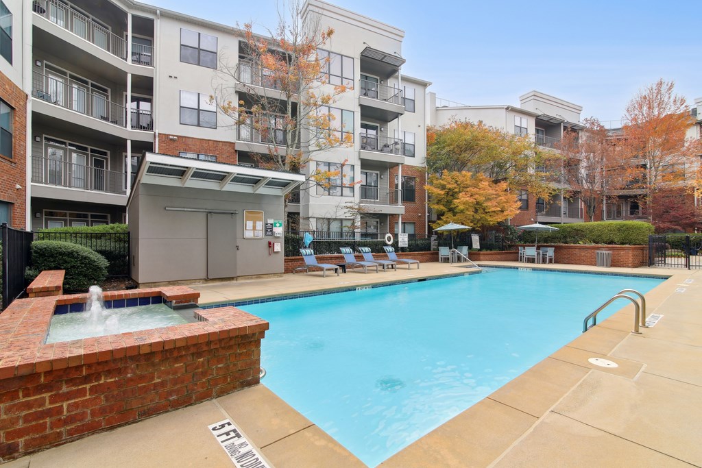 A large swimming pool in front of apartment buildings.
