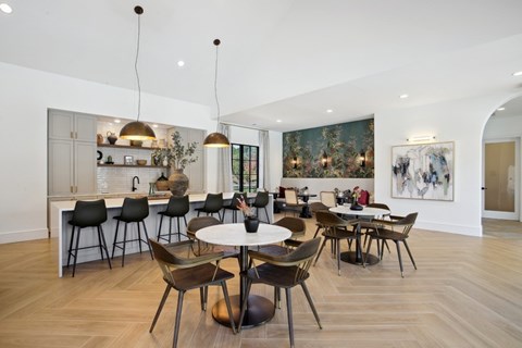 a dining room with tables and chairs and a kitchen