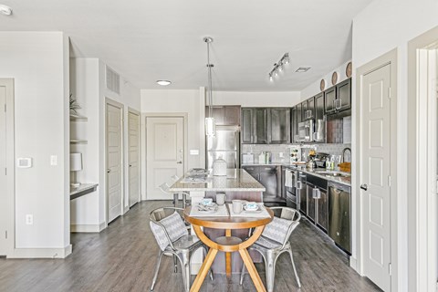 a kitchen with stainless steel appliances and a table and chairs