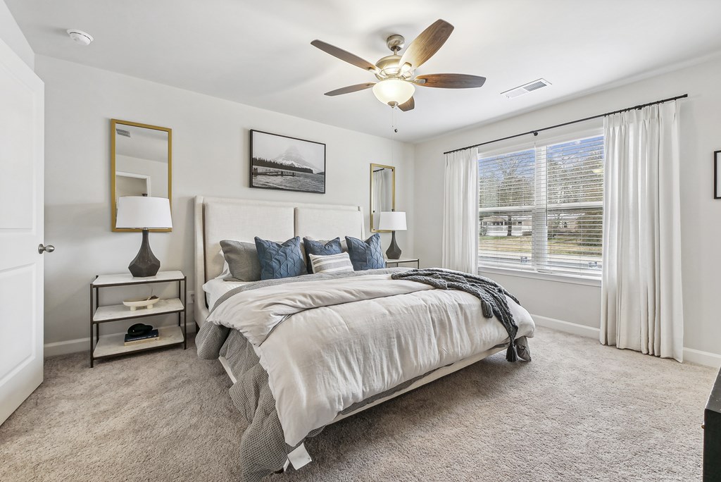 a bedroom with a bed and a ceiling fan