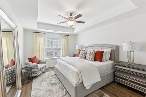 A bedroom with a large bed and a ceiling fan.