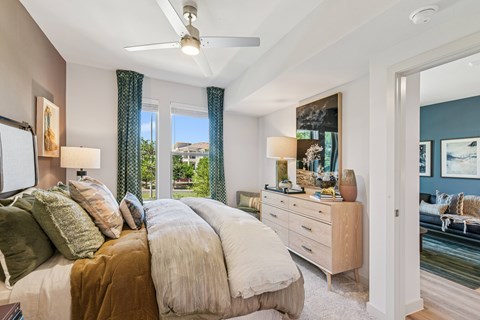 A bedroom with a large bed and a ceiling fan.