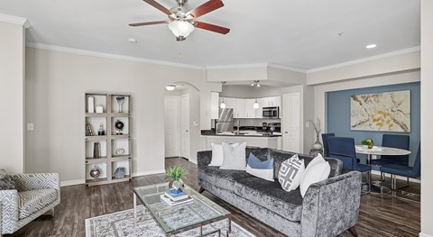 A living room with a grey couch and a ceiling fan.