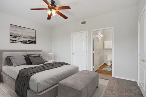 a bedroom with a large bed and a ceiling fan