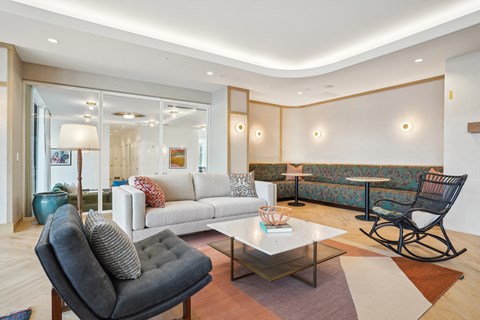 A living room with a grey chair and a white couch.