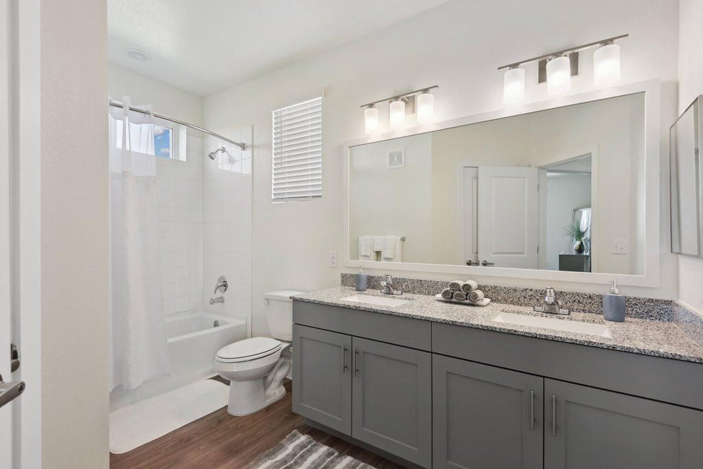 a bathroom with a large mirror and a toilet and a shower
