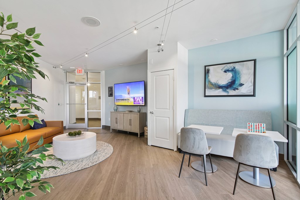 A living room with a television, two chairs, and a plant.