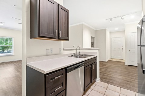 A kitchen with dark brown cabinets and a white countertop.