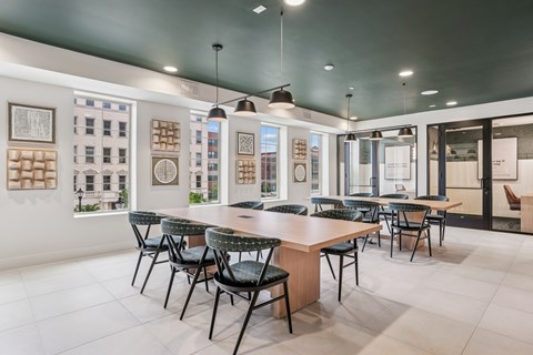 A modern dining room with a long table and chairs.