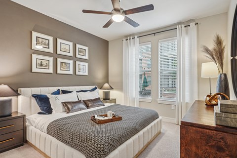 A bedroom with a large bed and a ceiling fan.