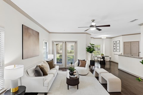 A living room with a white couch and a painting on the wall.