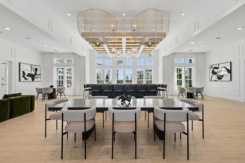 A large dining room with a long table and chairs.