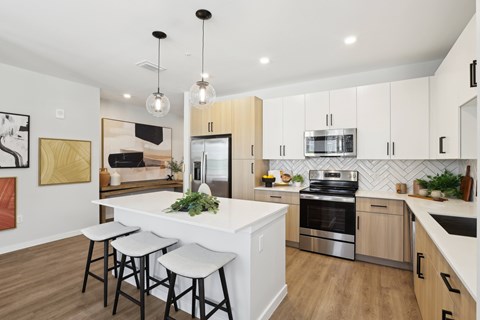 an open kitchen with a large island with three stools