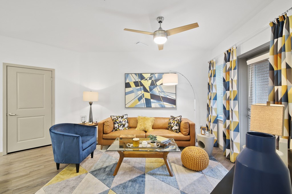 a living room with a yellow couch and a blue chair