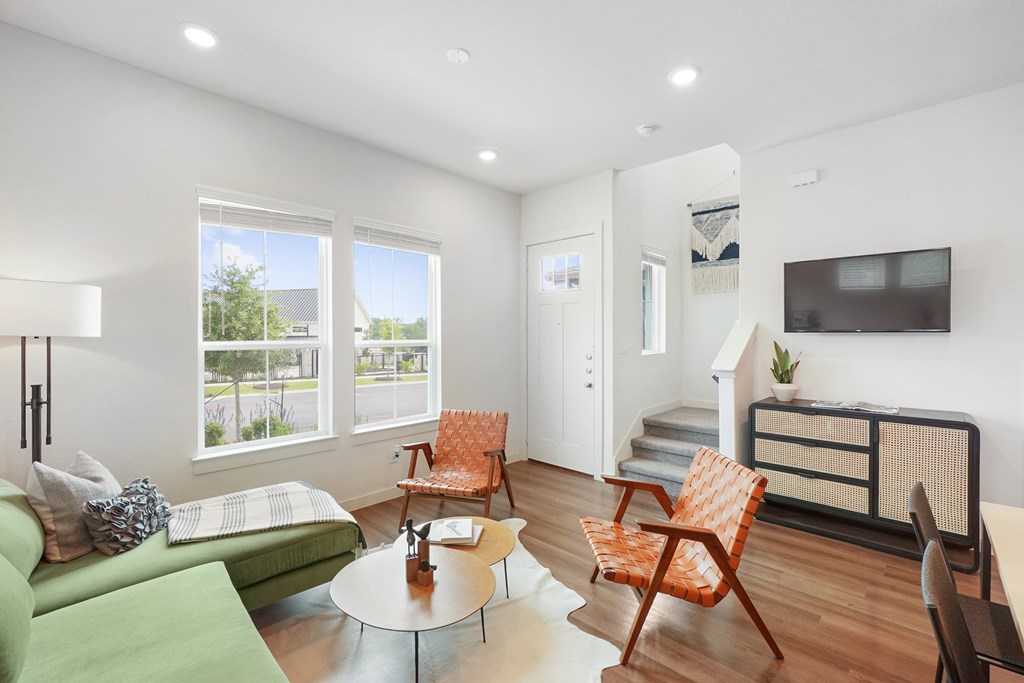 a living room with a green couch and orange chairs