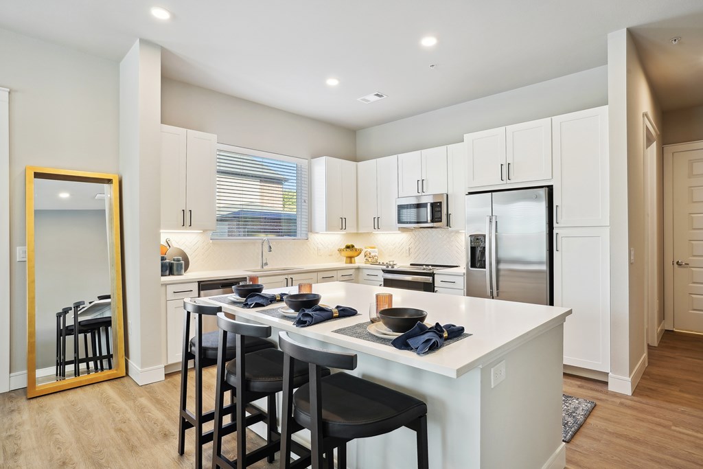 A large kitchen with oversized island and white cabinets