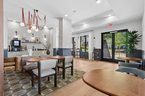 A modern dining area with wooden tables and grey chairs.