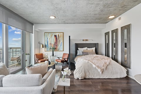 A bedroom with a large bed and a painting on the wall.
