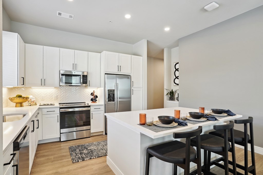 an open kitchen and dining area with a large island and stainless appliances