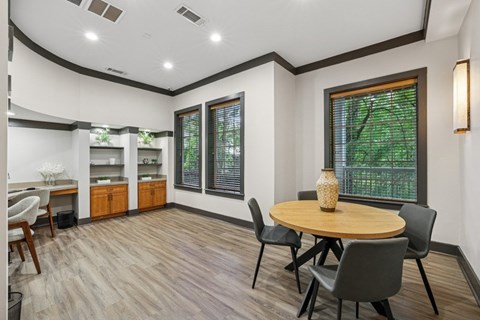 A dining room with a round table and chairs.